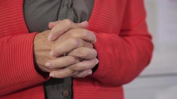 een oude vrouw, de docent maakt een handgebaar tijdens het praten video