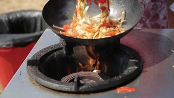 chef cozinhando com fogo na frigideira em um festival de comida de rua