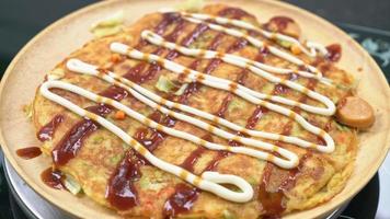 putting Japanese dried fish on Okonomiyaki or Japanese pizza video