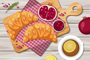 Croissant with pomegranate and a cup of lemon tea on the table vector