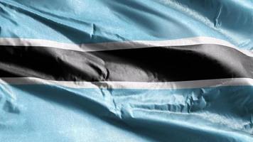 Botswana-Textilfahne weht auf der Windschleife. Botswana-Banner wiegt sich im Wind. Stoff Textilgewebe. voll ausfüllender Hintergrund. 10 Sekunden Schleife. video