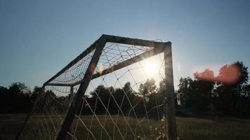 Fußballtorpfosten auf einem grünen Feld an einem warmen, sonnigen Tag am Abend. video