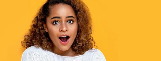 Surprised mixed African woman gasping isolated on yellow banner background with copy space photo