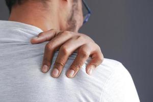 man suffering from neck or shoulder pain at home. photo