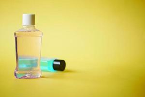 mouthwash liquid in a container on yellow background photo
