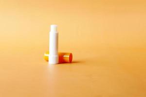 moisturising lip balm on orange background photo