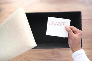 holding a paper with hand written donation text top view photo