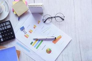 financial graph, calculator and notepad on table photo