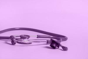 Graduation cap with stethoscope and numbers 2022 on violet background, closeup with copy space. Medical education concept. photo