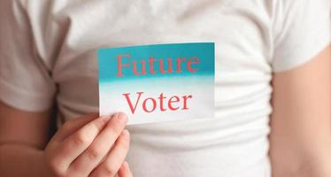 future voter sign in little girl's hand. Voting or making choice concept. photo
