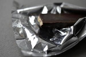 Chocolate candy in a wrapper on a gray background photo