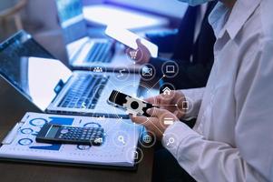 Businesswoman using mobile phone and laptop computer on white desk big data analytics with business intelligence concept. with VR chart and graph photo