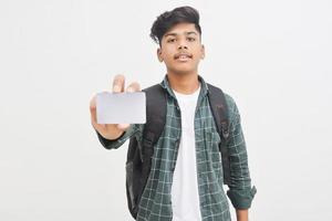 Young indian man showing debit or credit card on white background. photo