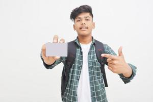 Young indian man showing debit or credit card on white background. photo