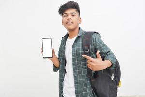 Young indian college student showing smartphone Screen on white background. photo