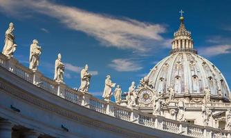 Decoration of statues on Saint Peter Cathedral with the Cupola in background - Rome, Italy photo