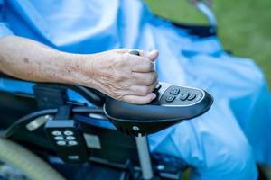 Asian senior or elderly old lady woman patient on electric wheelchair with remote control at nursing hospital ward, healthy strong medical concept photo