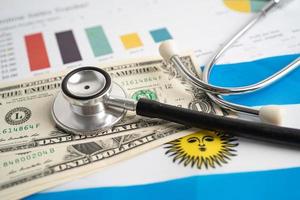 Black stethoscope on Argentina flag background with US dollar banknotes, Business and finance concept. photo