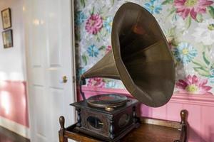 Old gramophone on table against decor wall photo