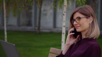 donna d'affari caucasica parlando e ridendo con il suo telefono cellulare. video