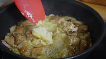 freír boletus de champiñones y cebolla con mantequilla en una sartén caliente video