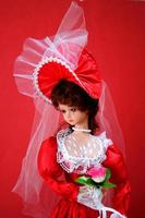 mirada elegante de una muñeca en traje de novia rojo foto