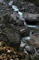 Water running down the hill through rocky terrain photo