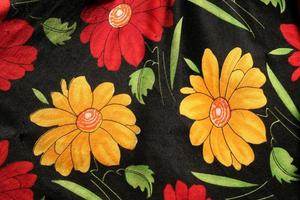 Colouful floral design isolated over black on fabric photo