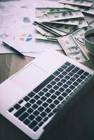 Working place of trader. The table covered by cash notes, keyboard and financial charts. Business financial working. photo