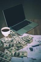 lugar de trabajo del comerciante. la mesa cubierta por billetes de caja, teclado y gráficos financieros. trabajo financiero empresarial. foto