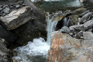 Water flowing between rocks results in foamy splash photo