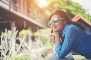 Portrait of  young hipster woman relaxing on a balcony on a sunny summer. Smiling enjoy with nature.