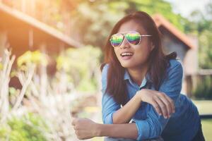 retrato de una joven hipster relajándose en un balcón en un verano soleado. sonriendo disfrutar con la naturaleza. foto