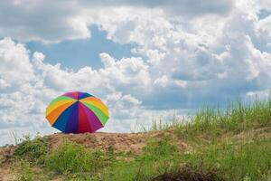 rainbow umbrella resting on the ground photo