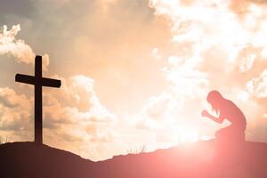 Silhouette of woman praying over beautiful sky background photo