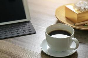 taza de café y teclado inteligente de base de mesa digital, caja de regalo dorada y bandeja de madera redonda, lápiz de color sobre mesa de madera, efecto de filtro foto