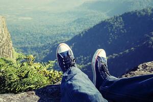 Man laying feet top of the mountain photo