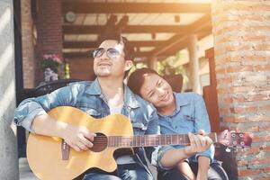 Hipster couple sitting relaxed with nice atmosphere with first date enjoys playing guitar as a great time together. photo