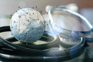 Studio macro of a stethoscope and texture globe with digital tablet  as medical network concept photo