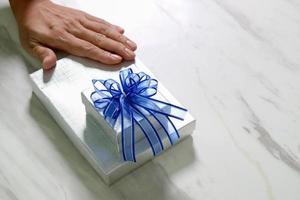 gift giving,man hand holding a gift box in a gesture of giving.blurred background photo