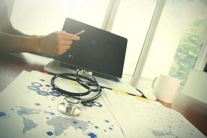 Doctor working with laptop computer in medical workspace office and medical network media diagram as concept photo