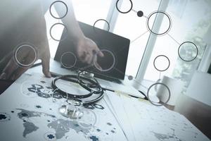 Doctor working with laptop computer in medical workspace office and medical network media diagram as concept photo