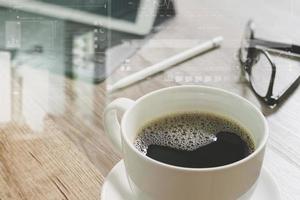 Coffee cup and Digital table dock smart keyboard,eyeglasses,stylus pen on wooden table,filter effect photo