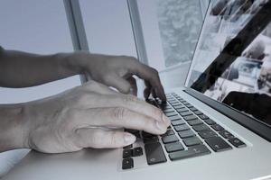 doble exposición de la mano del hombre de negocios trabajando en una computadora portátil de pantalla en blanco en un escritorio de madera como concepto foto