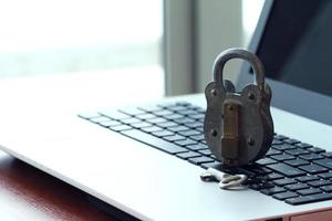 concepto de seguridad en Internet: candado antiguo y llave en el teclado de la computadora portátil foto