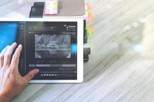 mano de hombre de negocios que asiste a una videoconferencia con una tableta digital y una tableta en el escritorio de la oficina
