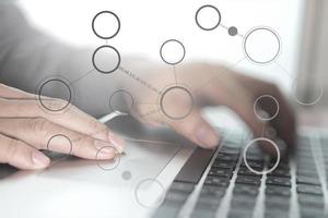 Close up of business man hand working on laptop computer with social media diagram and chart graph on wooden desk as concept photo