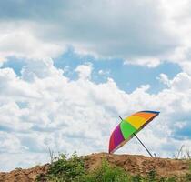 rainbow umbrella resting on the ground photo