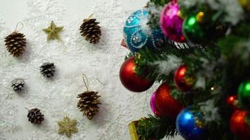 concepto de temporada de saludo ajuste manual de adornos en un árbol de navidad con luz decorativa foto