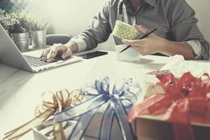 Gift giving Creative Hand choosing and hand with gift. Gift delivery, surprise,latop computer and  smart phone on mable desk,filter film effect photo